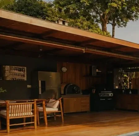 Cozinha externa e deck de madeira da Casa Paraíso, entre as árvores
