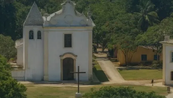 Igreja branca entre árvores no centro histórico de Porto Seguro